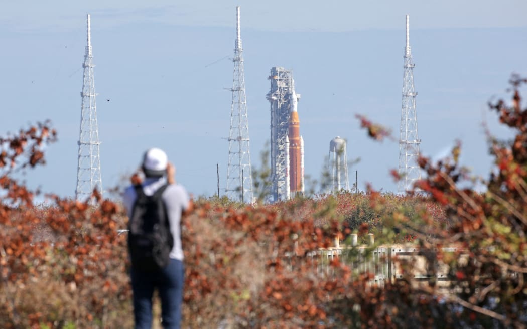 NASA's Artemis II Space Launch System (SLS) rocket and Orion spacecraft are seen in the distance at Launch Pad 39B at Kennedy Space Center in Cape Canaveral, Florida, on February 20, 2026. NASA performed their second wet dress rehearsal prior to sending four astronauts to the moon for the first time in more than 50 years. NASA officials said they are targeting March 6 for the crewed flight to the moon. (Photo by Gregg Newton / AFP)