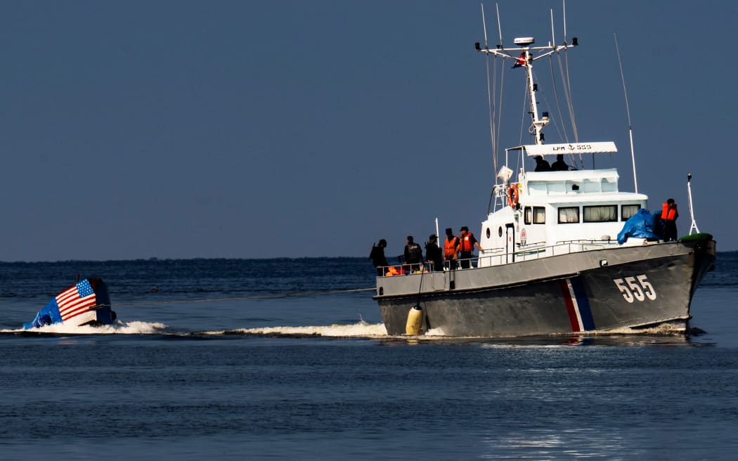 Cuban Coast Guard tows a boat attempting to leave the country in Havana on December 12, 2022. (Photo by YAMIL LAGE / AFP)