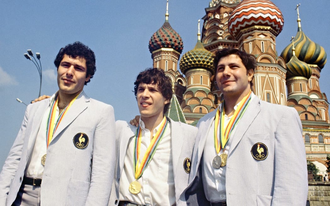 French judokas, medalists at the1980 Olympic games face the cameras in front of Saint-Basil, Moscow Red Square, 1980. Angelo Parisi (R) won gold in the Heavyweight category and silver in the Open, Bernard Tchoullouyan (C) got bronze in the Half Middleweight and Thierry Rey (L) took gold in the Extra Lightweight category. (Photo by EPU / AFP)