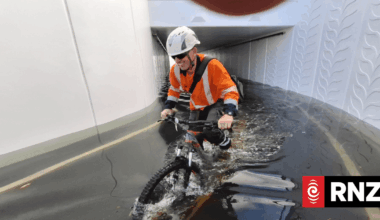 Cyclists thigh-deep in water days after rain