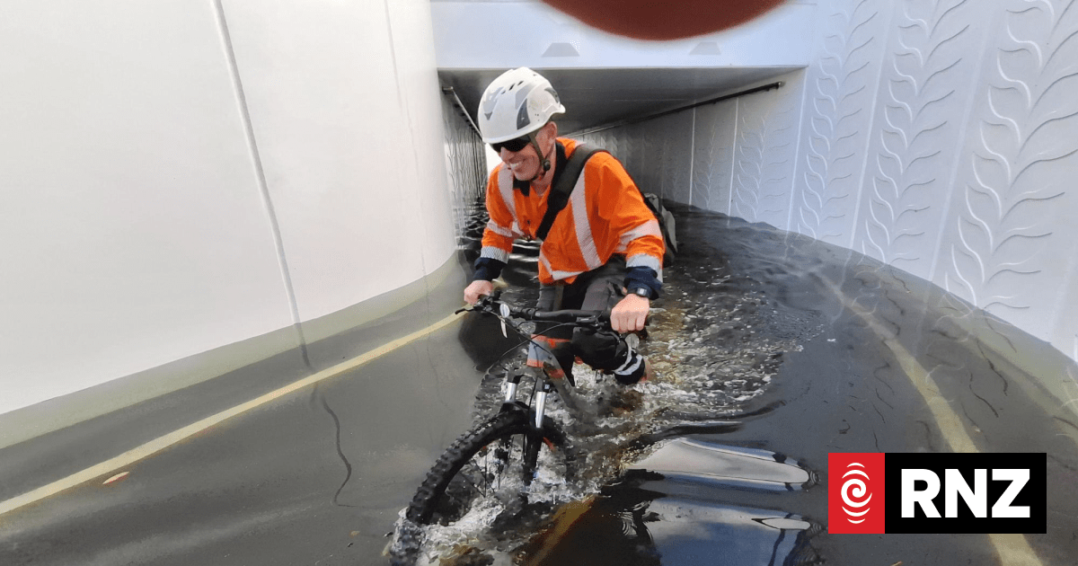 Cyclists thigh-deep in water days after rain