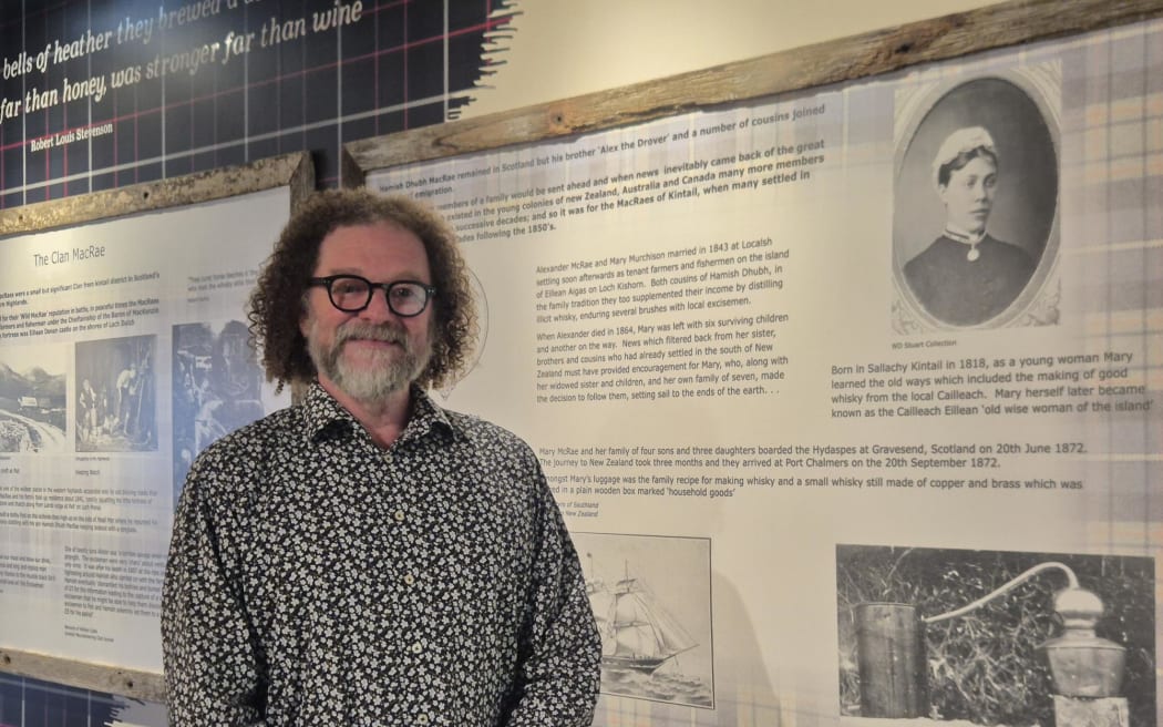 Museum curator Jim Geddes alongside a portrait of Mary McRae, the 'moonshine matriarch'.