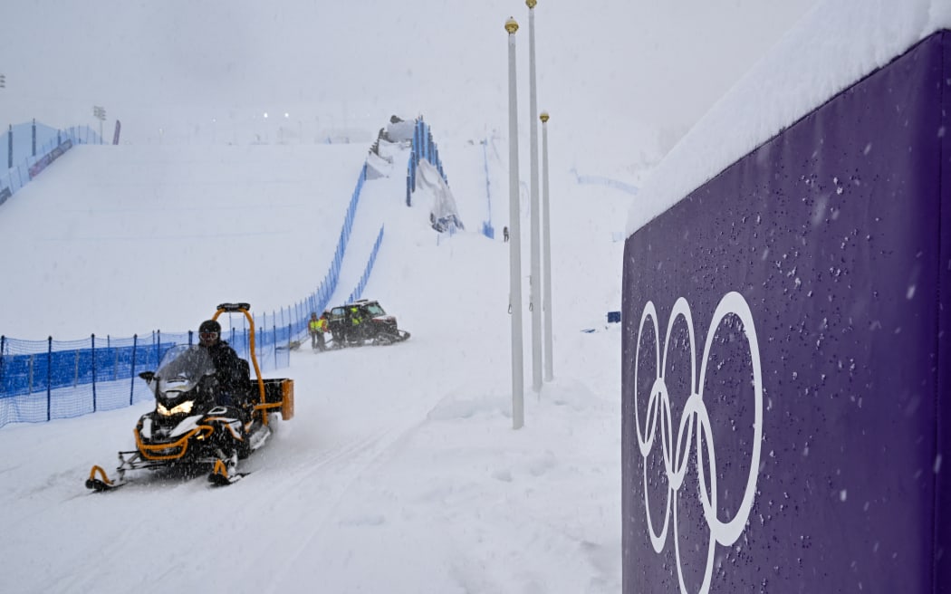 A snowmobile drives past a placard displaying olympic rings, shortly after the cancellation due to weather conditions of the snowboard women's slopestyle final run 1 during the Milano Cortina 2026 Winter Olympic Games at Livigno Snow Park, in Livigno (Valtellina), on February 17, 2026.
