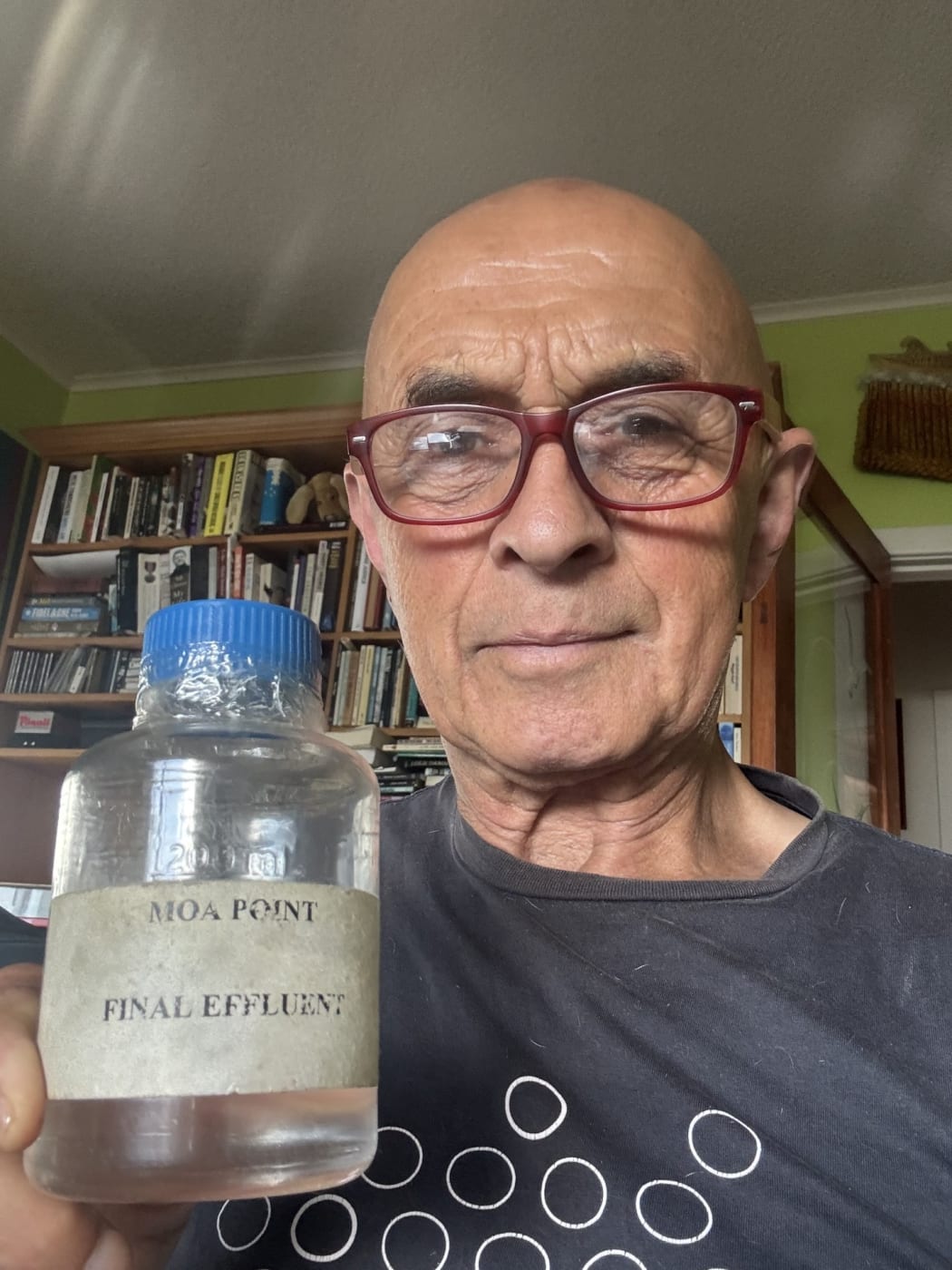 Ray Ahipene-Mercer with his jar of 24-year-old water from Moa Point sewage treatment plant.