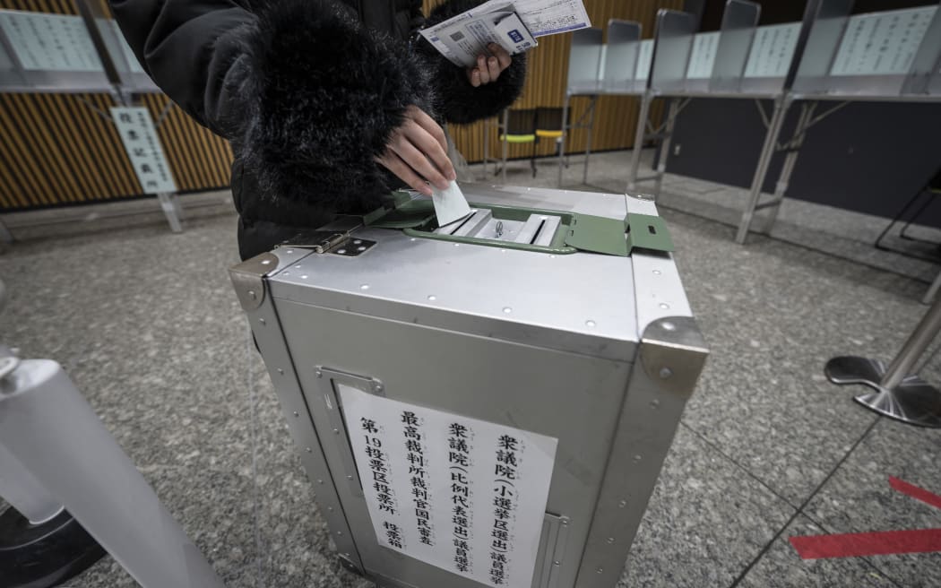 A voter casts their ballot in the House of Representatives election at a polling station in Tokyo on February 8, 2026. Japan voted in snap elections February 8 with Prime Minister Sanae Takaichi hoping to turn a honeymoon start into a resounding ballot box victory that could rile China and rattle financial markets. (Photo by Yuichi YAMAZAKI / AFP)