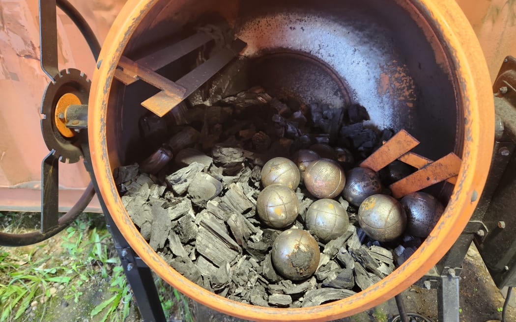 An old cement mixer filled with biochar ready for crushing with petanque balls