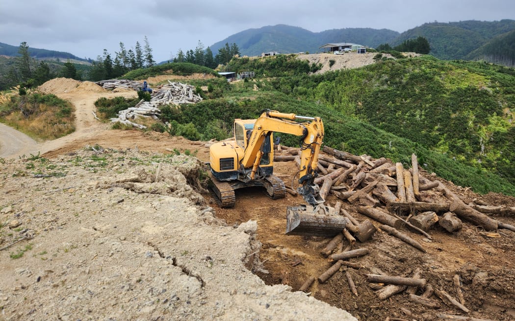 Matt and Debbie Welton's property with a digger in the foreground clearing the land of slash