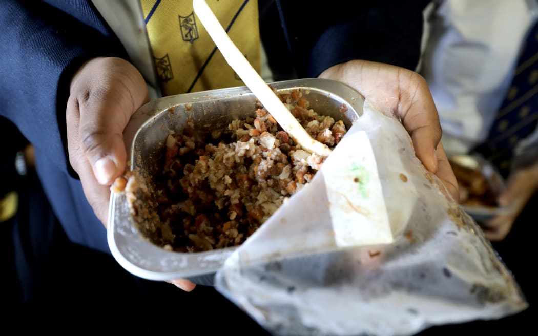 Year 13 student Divya Kumar holds an example of a school lunch