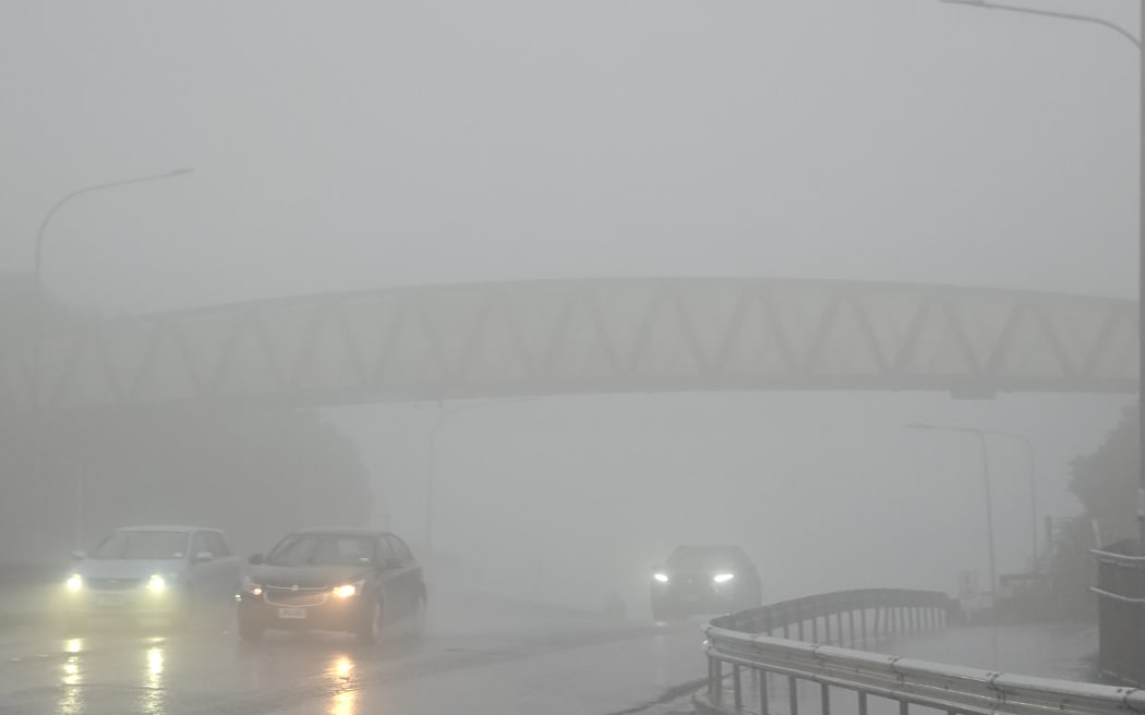 Cars driving through thick fog and heavy rain at the summit of the Wainuiomata hill, over Lower Hutt, during storms on Sunday 18 August, 2024.