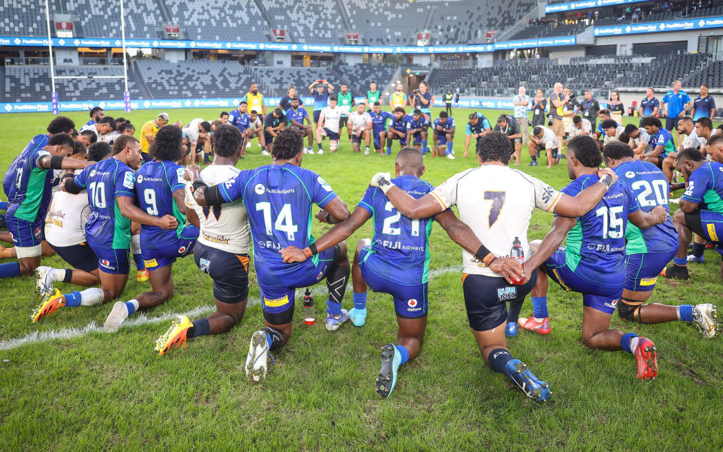 Players from Fijian Drua and Moana Pasifika pray together in the centre of the ground after the Super Rugby Pacific Round 13 match between the Fijian Drua and Moana Pasifika at Commbank Stadium in Sydney, Saturday, May 14, 2022.