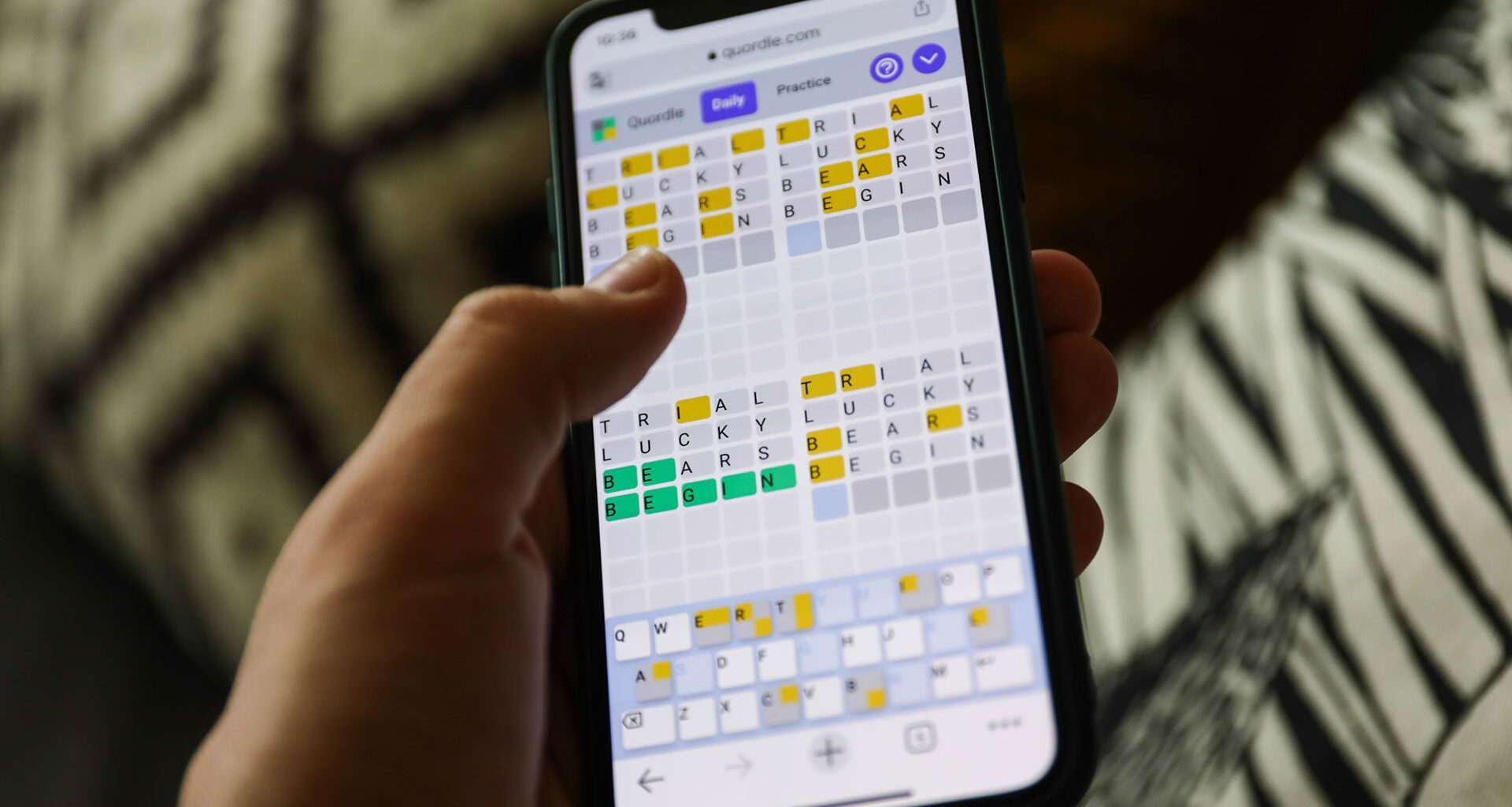 Quordle on a smartphone held in a hand