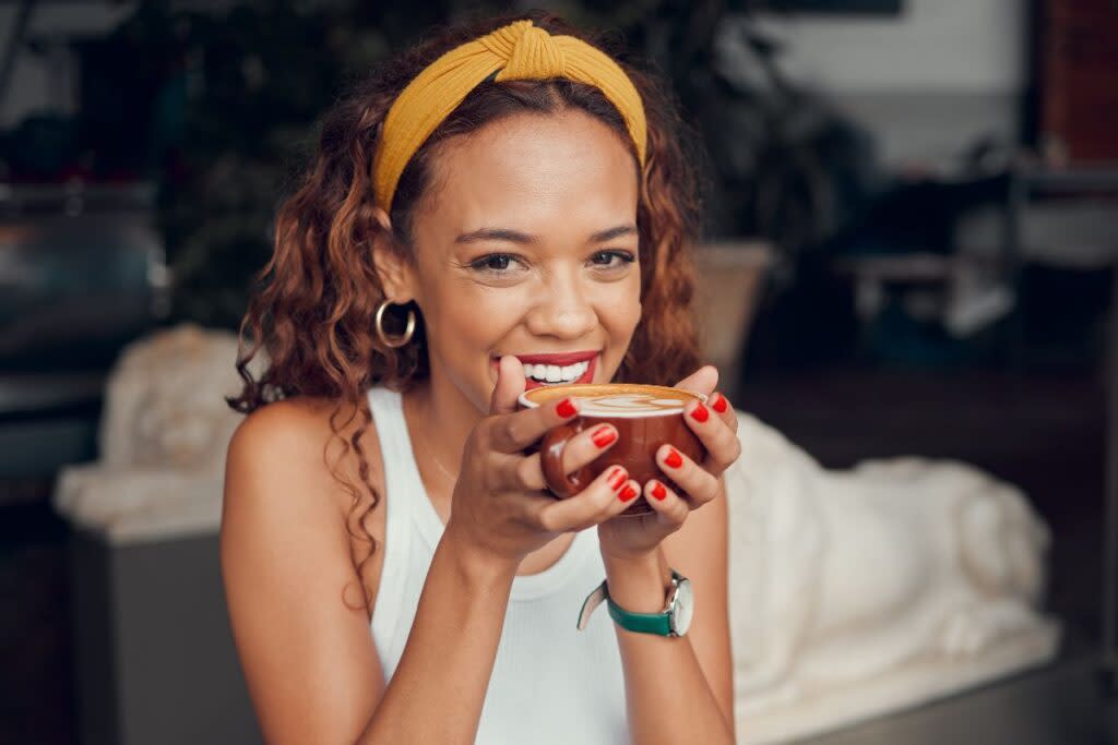 woman smiling holding coffee