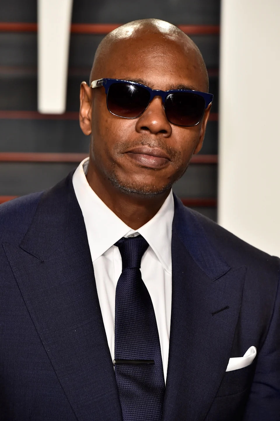 Man in a suit with sunglasses at a formal event