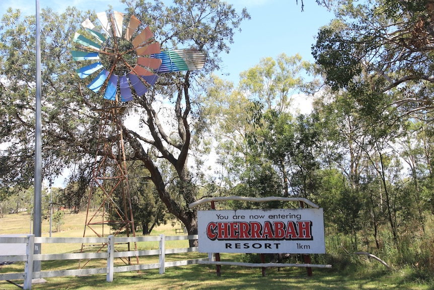 cherrabah resort sign, next to gate and colourful windmill