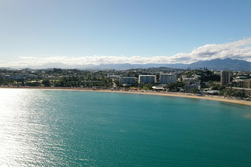 An aerial view showing teal water and hotel buildings near Anse Vata beach in New Caledonia.