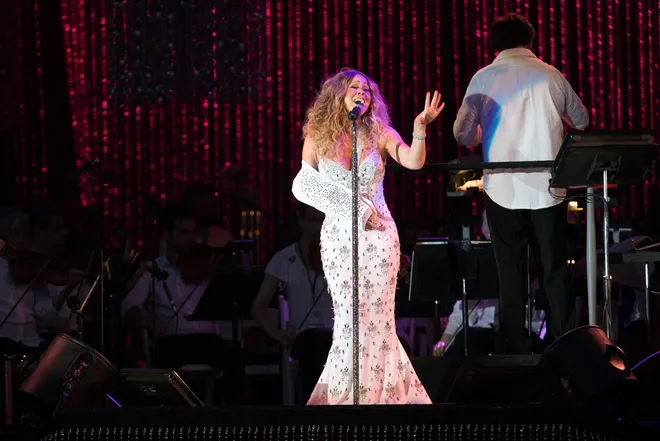 Singer Mariah Carey wears a sling while performing with the New York Philharmonic at the MLB All-Star Charity Concert benefiting Sandy Relief on the Great Lawn of Central Park in New York in 2013. She was injured during the filming of the music video for "#Beautiful."