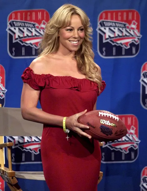 Singer Mariah Carey holds a football at a news conference featuring the pre-game entertainers for Super Bowl XXXVI in New Orleans January 31, 2002.