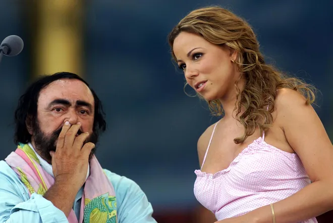 Pop singer Mariah Carey and Luciano Pavarotti pause during a dress rehearsal May 31, 1999, for the Pavarotti & Friends '99 concert.