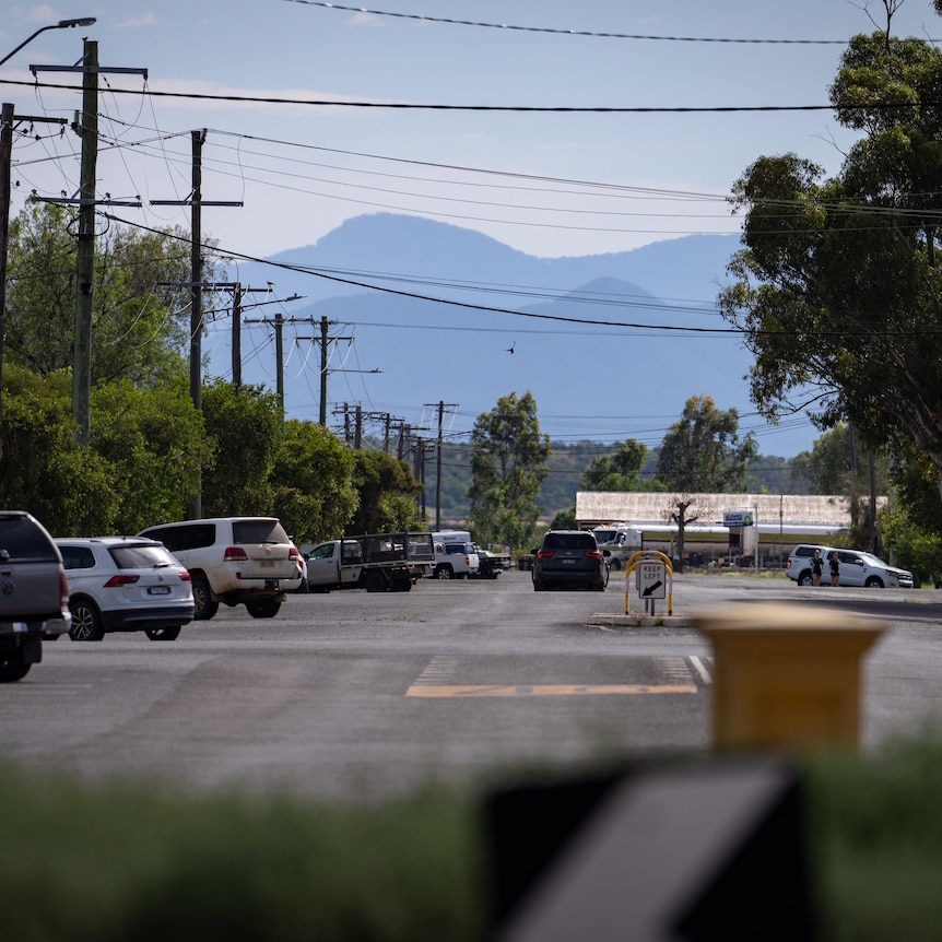 A view of a street with cars and mountains in the distance