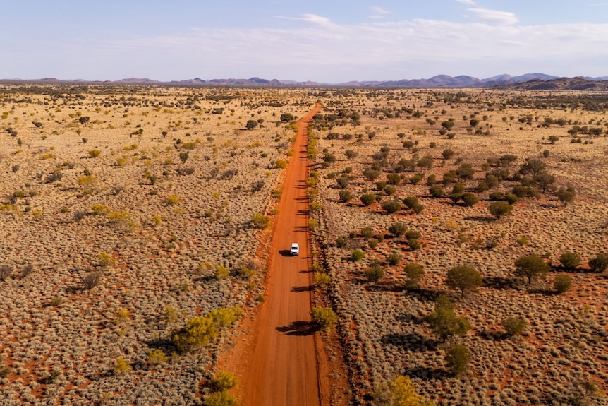 A long red dirt road in the outback.