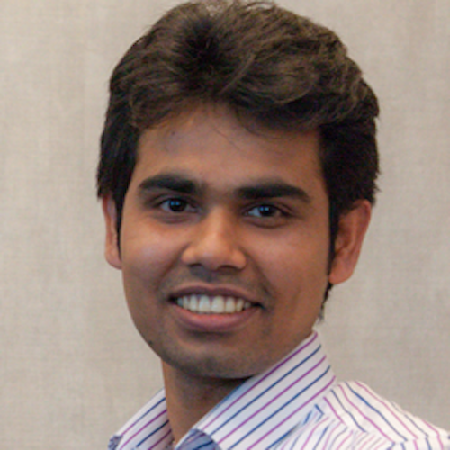 Smiling man with brown hair and dark complexion.