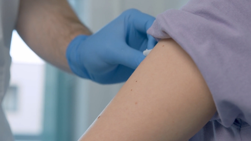 Nurse giving a vaccine injection into an adult patient’s upper arm