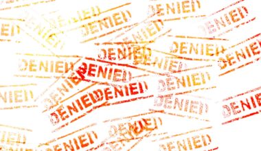 Stamp of the word "denied" repeated many times in yellow and red