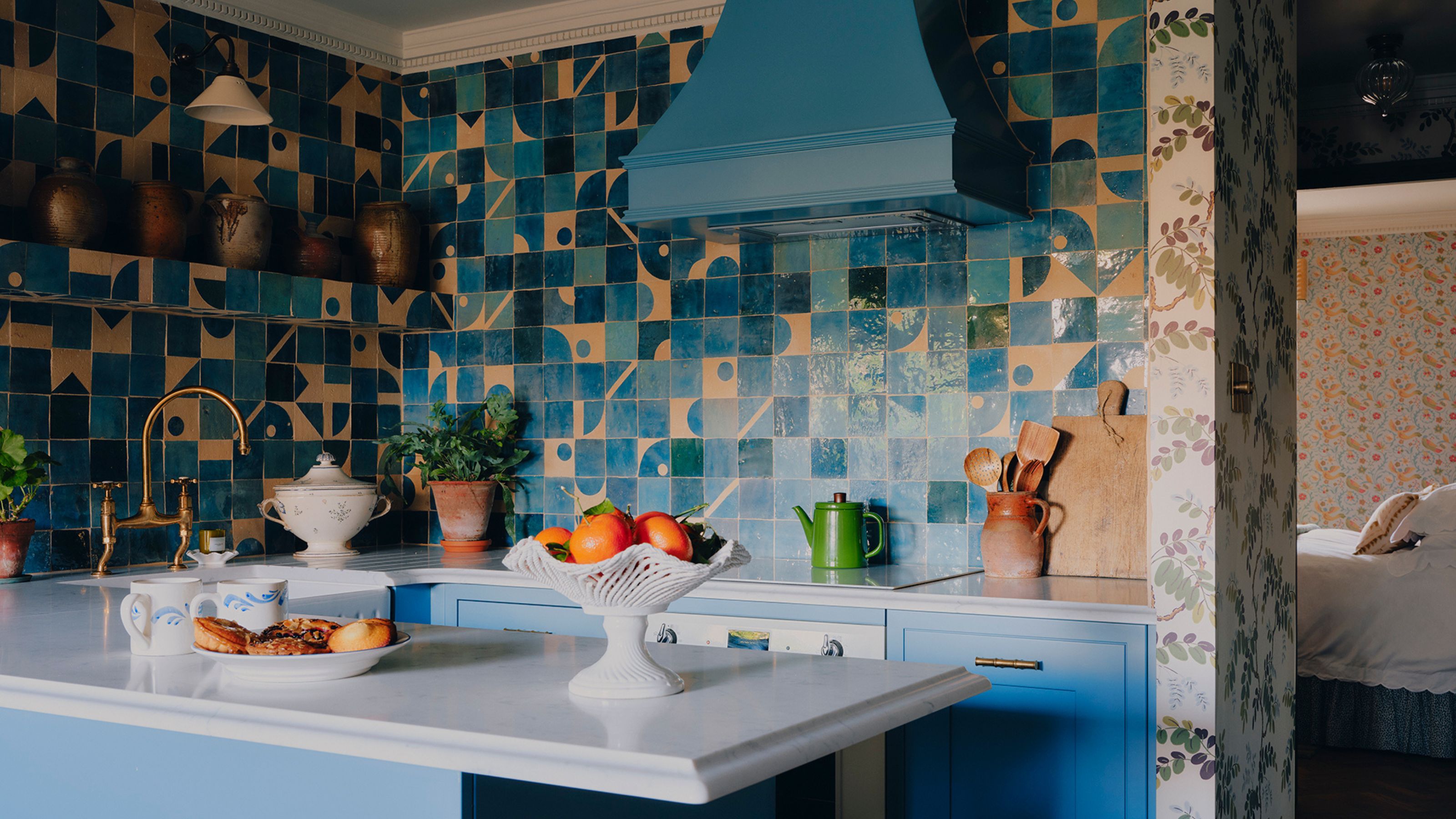 a bright blue kitchen in london with mix and match blue patterned zellige tiles