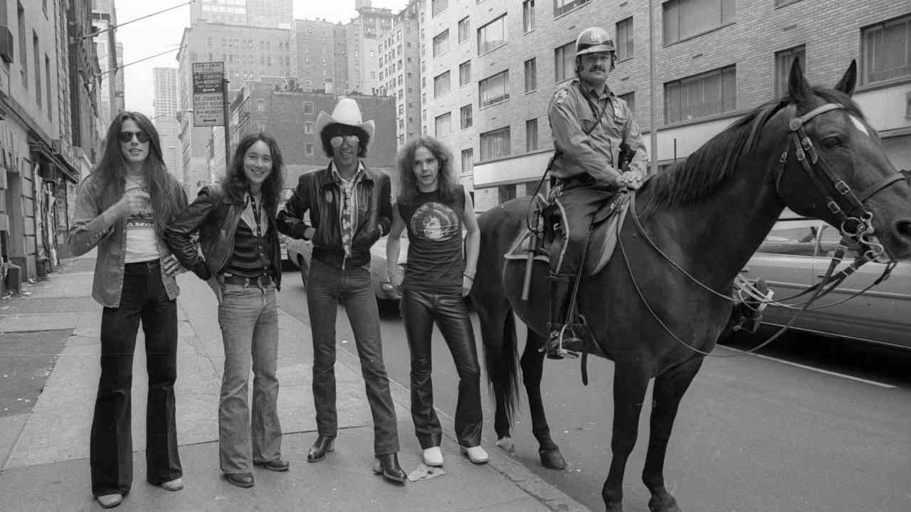 Thin Lizzy posing for a photograph on a New York street alongside a mounted police officer
