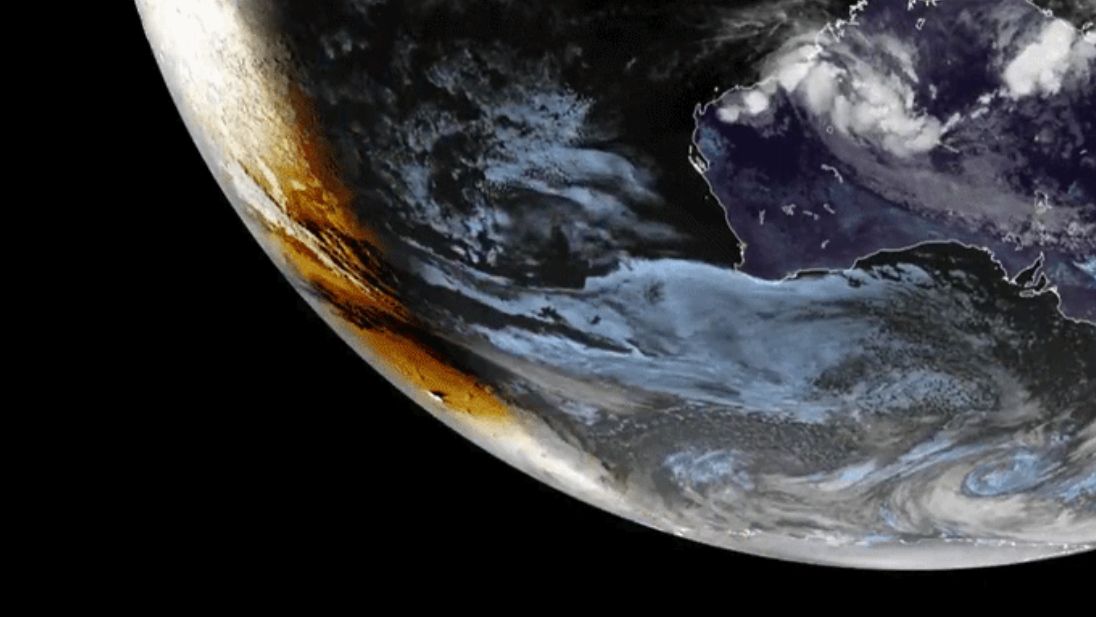 The shadow of the moon is visible over Earth's southern surface to the left of the line separating night from day.