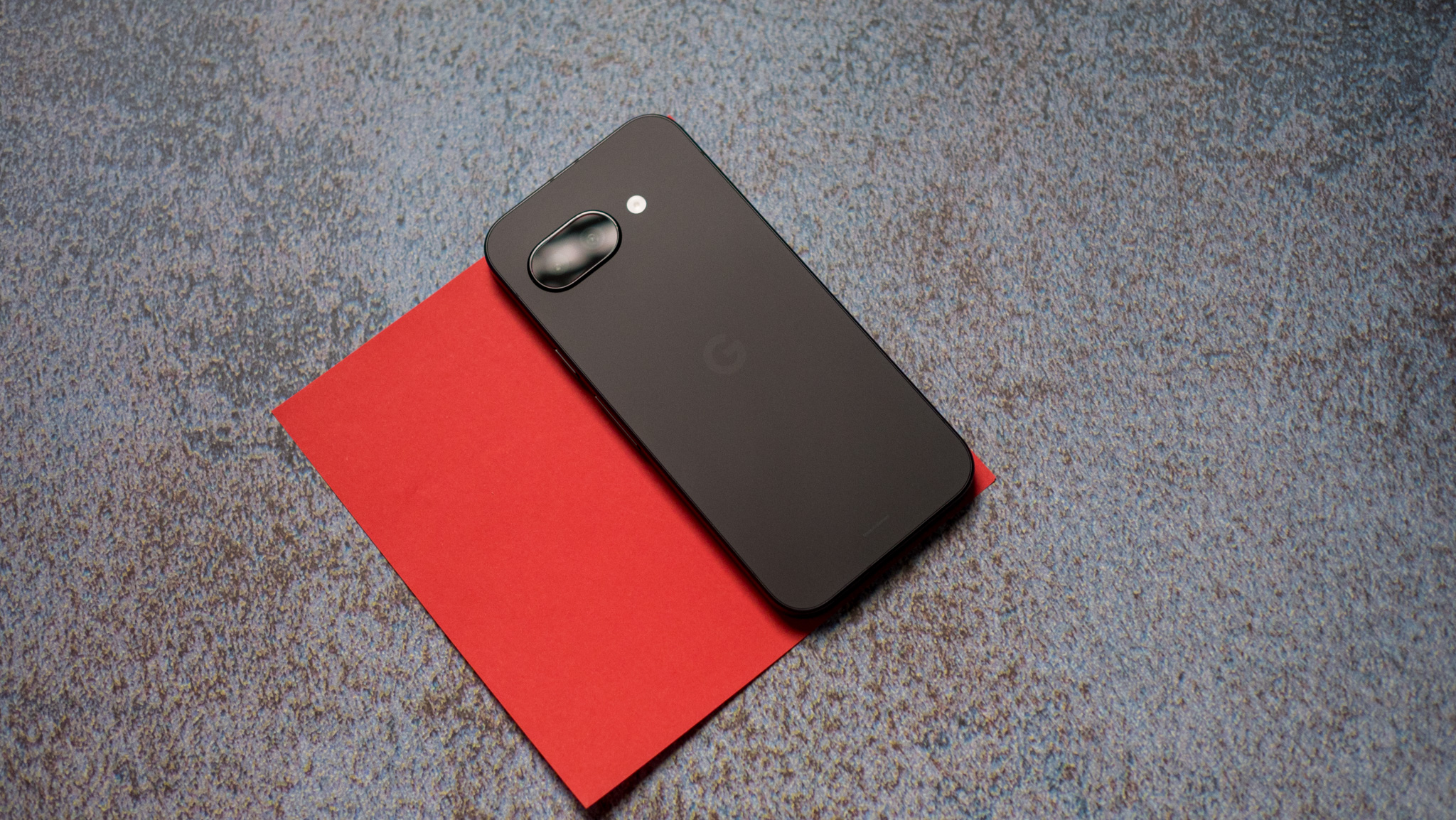 Google Pixel 9a back on a red background