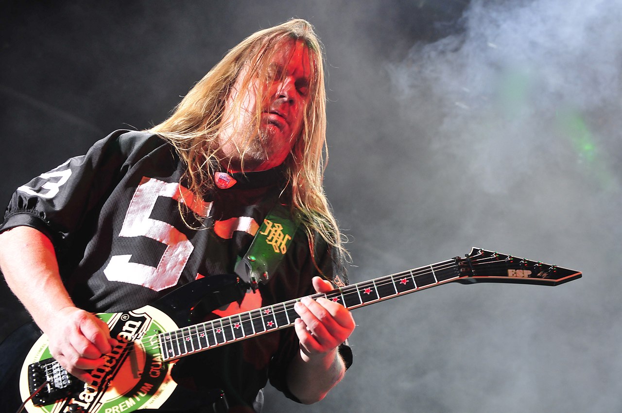Jeff Hanneman of Slayer performing live on stage, playing guitar with intense energy.