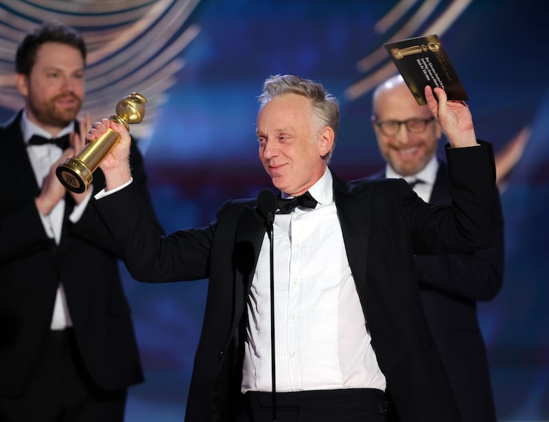 Mike White accepts his Golden Globe award.