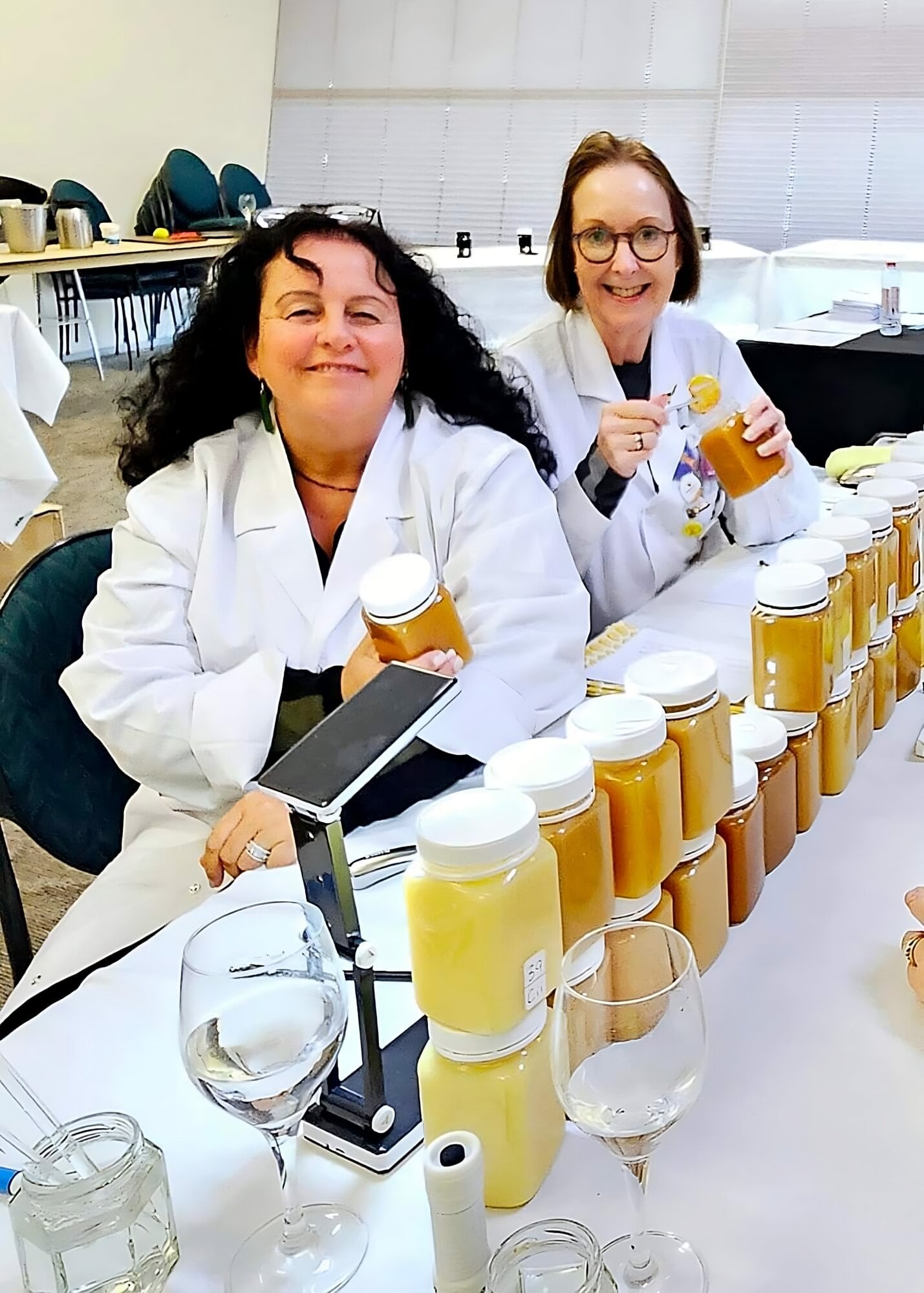 Jody Mitchell judging New Zealand honey with Maureen Conqueror.