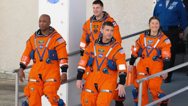 Four astronauts in orange spacesuits
