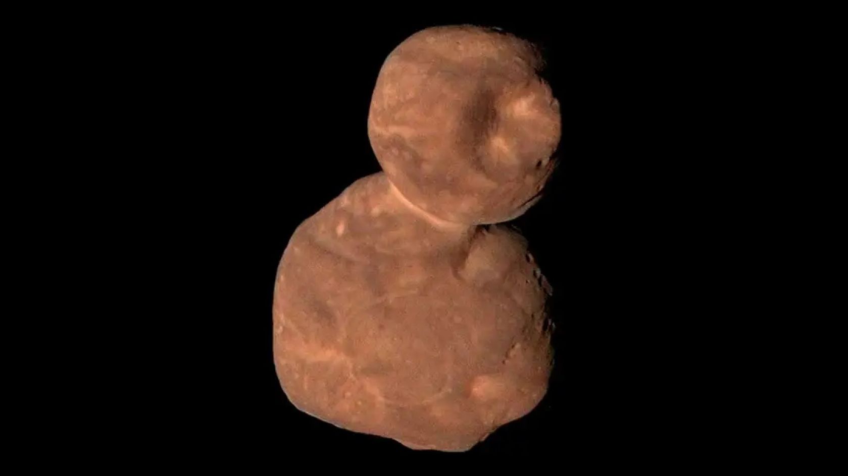 closeup image of a lumpy asteroid-like object in deep space that looks like a reddish-brown snowman