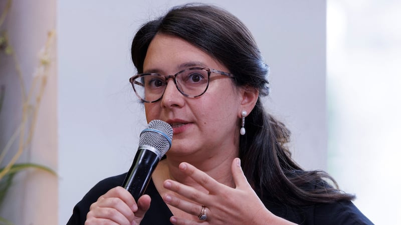 Bari Weiss holds a microphone up to his mouth in a photo 