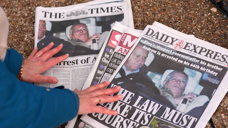 A journalist looks at today's newspaper front pages in London, Friday, Feb. 20, 2026