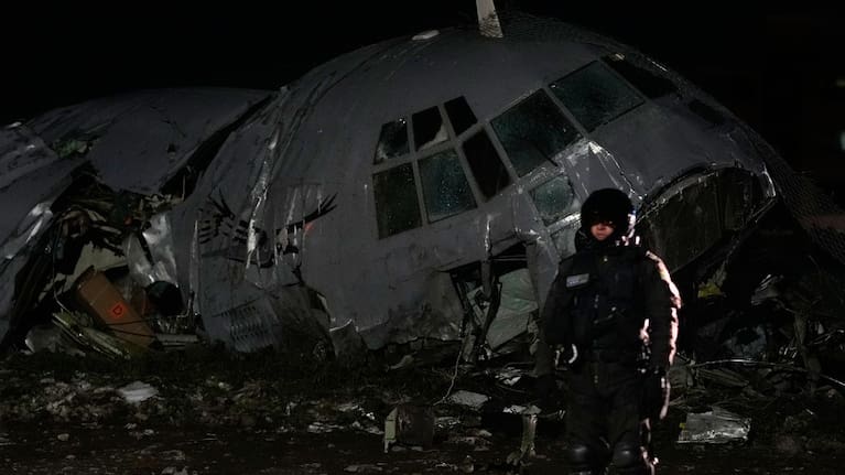 A military police officer stands next to a plane that crashed in El Alto, Bolivia.