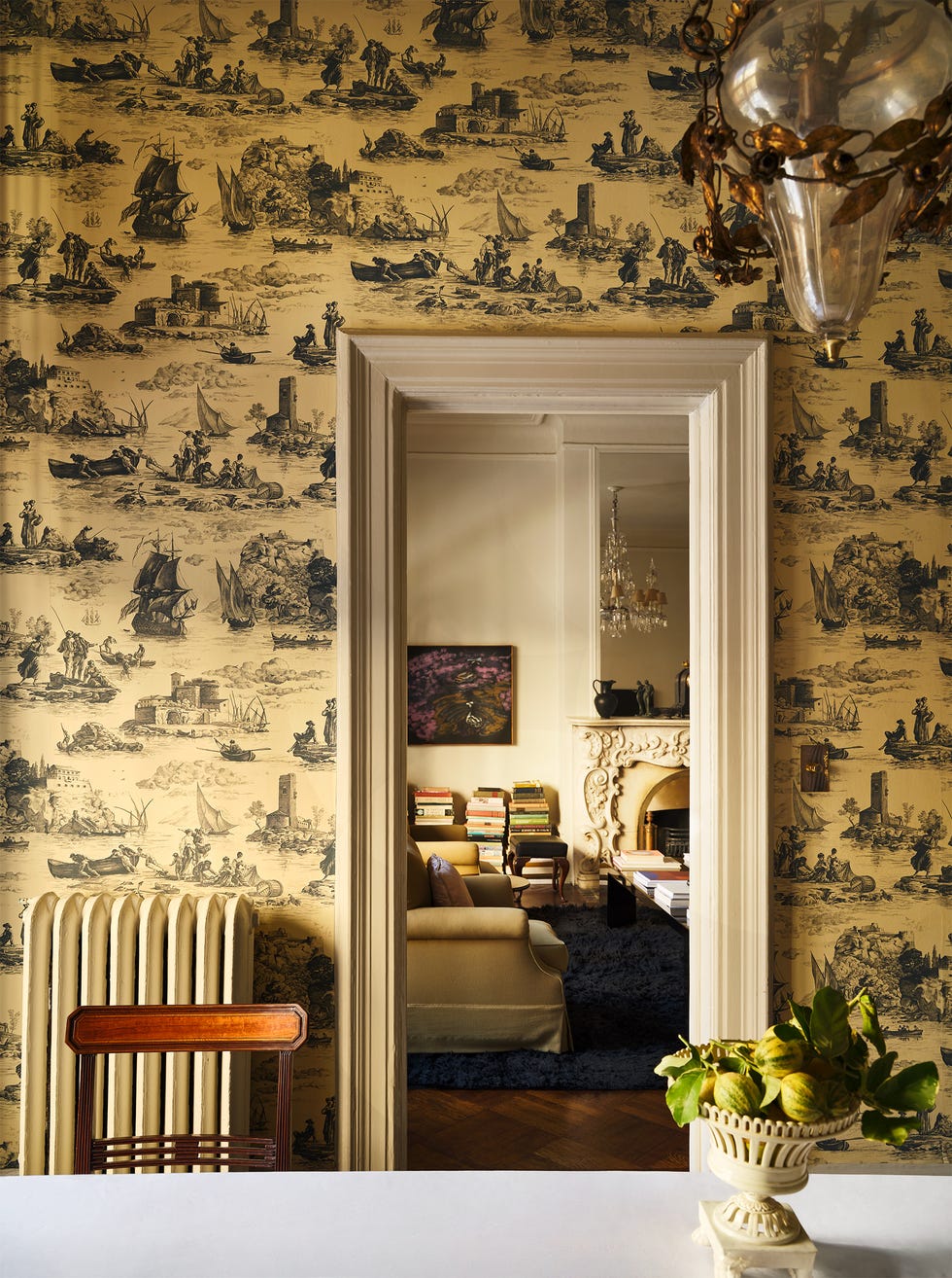 Interior view through an ornate doorway with a decorative wall and visible living area.