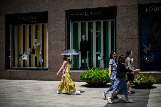 Pedestrians walk past luxury fashion shops in the Gangnam district of Seoul on June 3, 2022. Photo by AFP