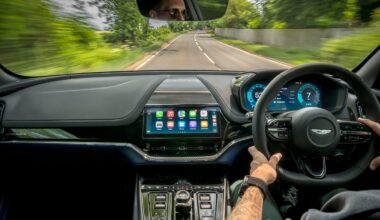 Someone driving an Aston Martin using CarPlay Ultra