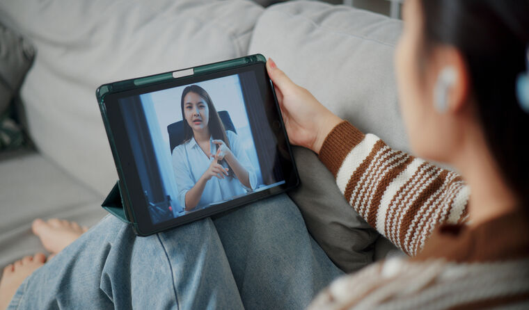 Young woman in telehealth consult on laptop