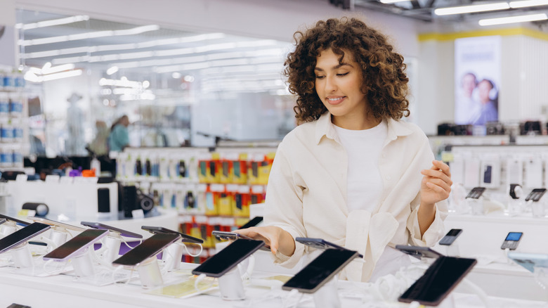 woman comparing two phones at the store