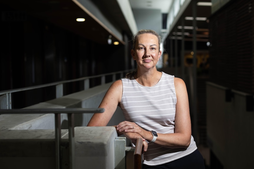 A woman in a grey singlet looking into the camera