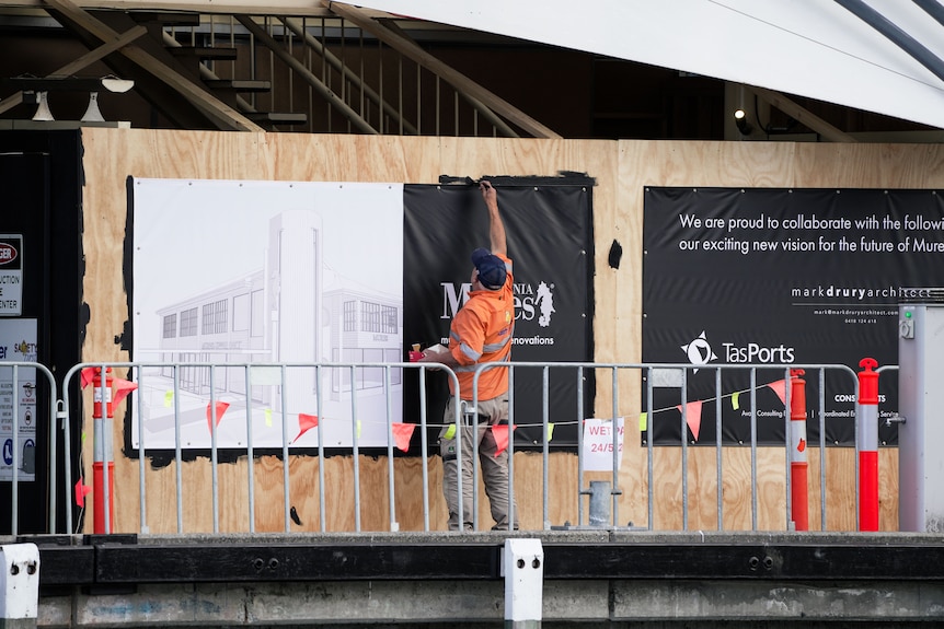 Men in red and orange jackets working on construction site.