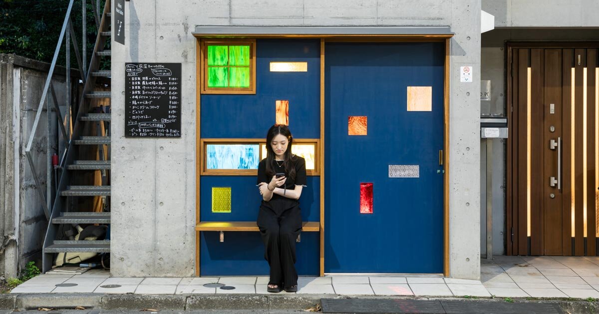 colored glass apertures reveal lively tokyo bar through bright blue entrance