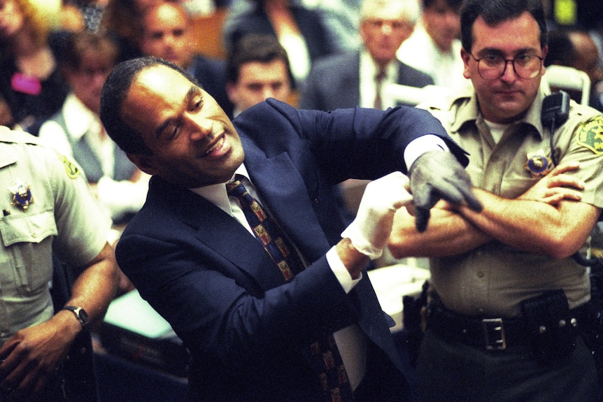 A man in a suit with a black glove. 