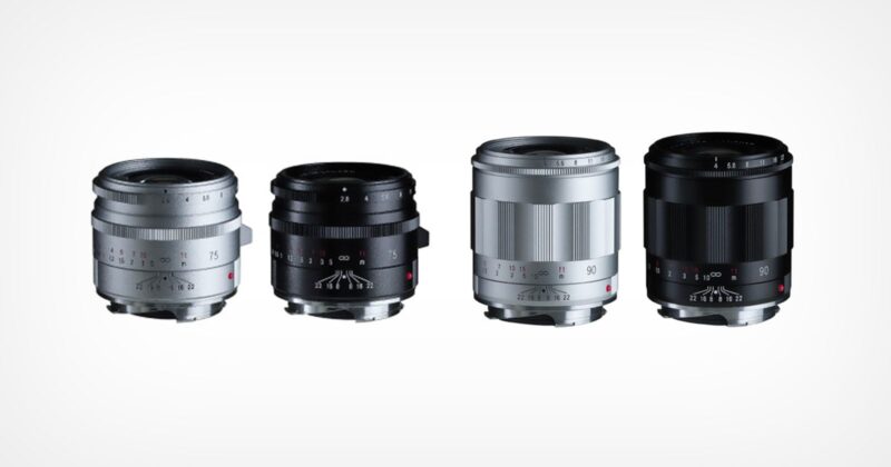 Four camera lenses are arranged in a row on a white background, with two lenses in silver and two in black. The lenses are compact and have visible focus and aperture markings.