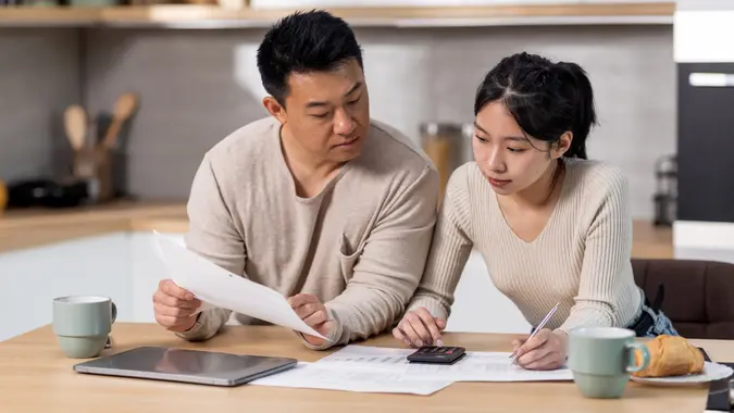 Family counting monthly expenses, kitchen interior stock photo